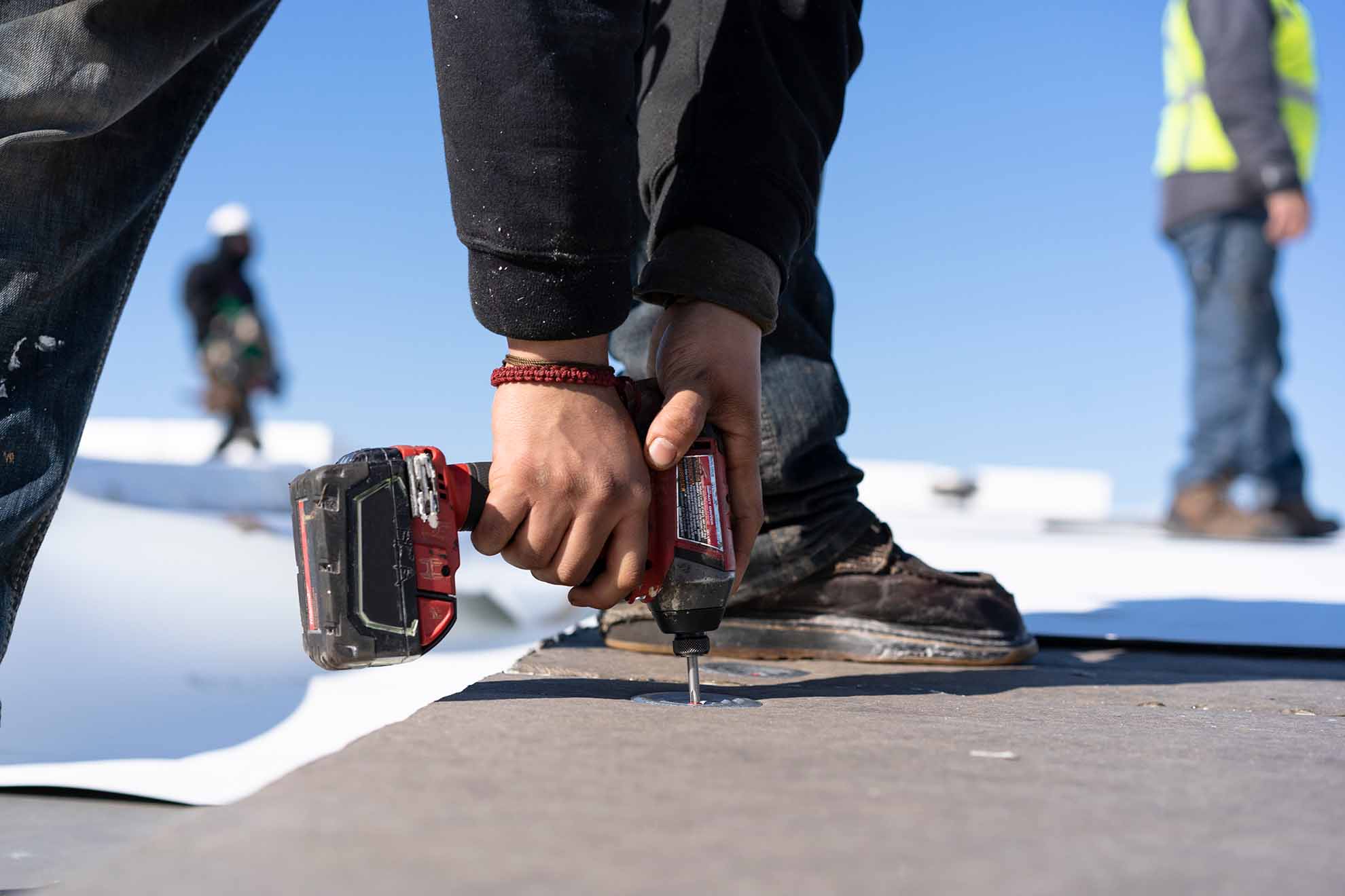 hands of a construction worker drilling into a roof