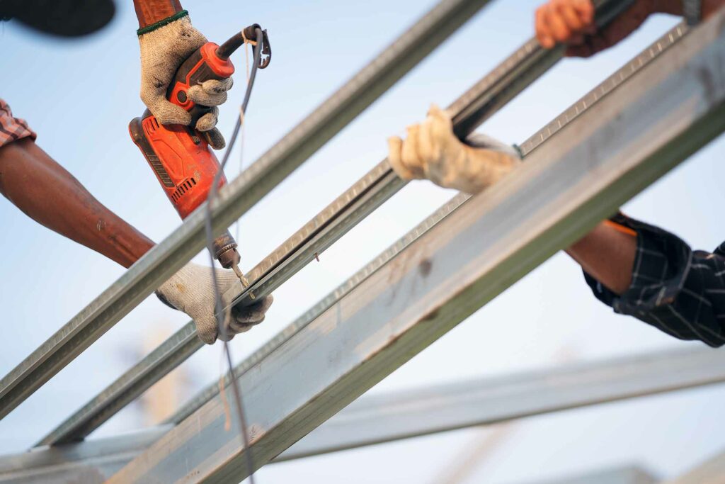 man worker uses a power drill to attach a cap