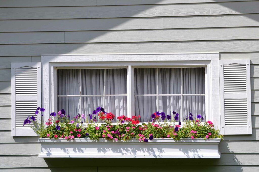 new siding with flower bed in front of window